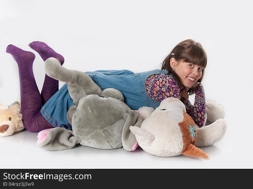 Cheerful girl playing with his toys on white background