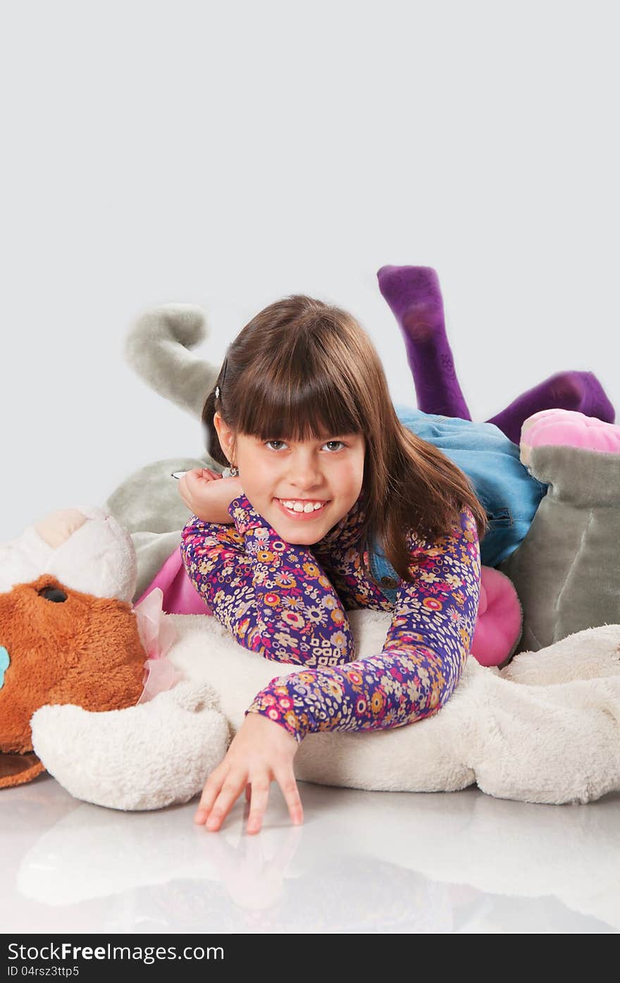 Cheerful girl playing with his toys on white background