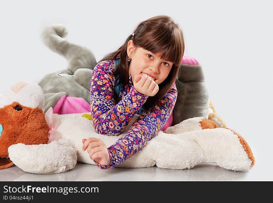 Cheerful girl playing with his toys on white background