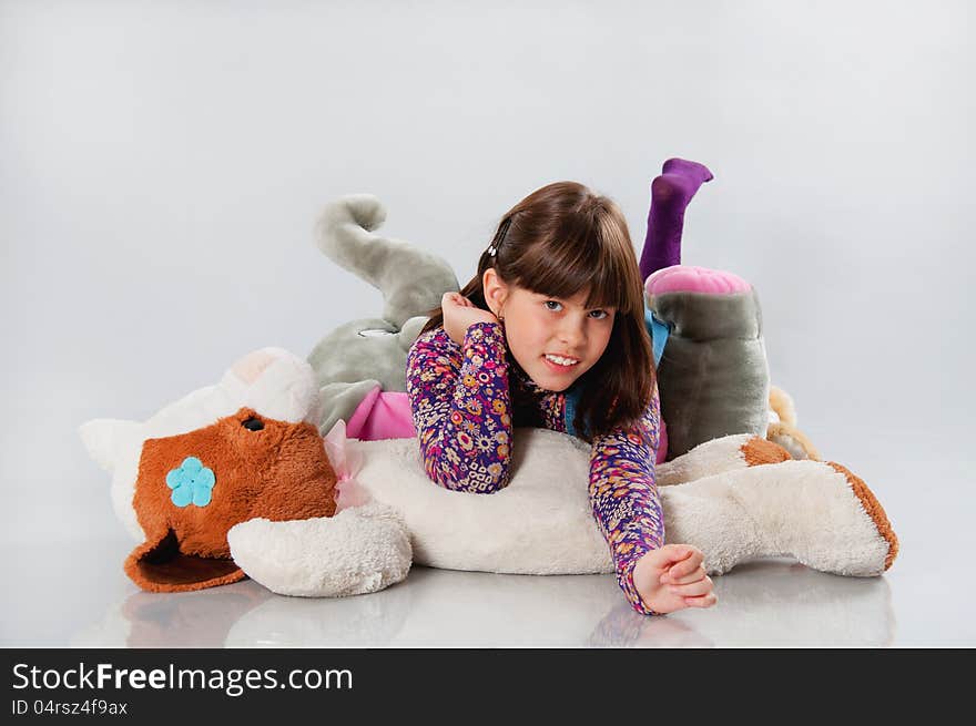 Cheerful girl playing with his toys on white background