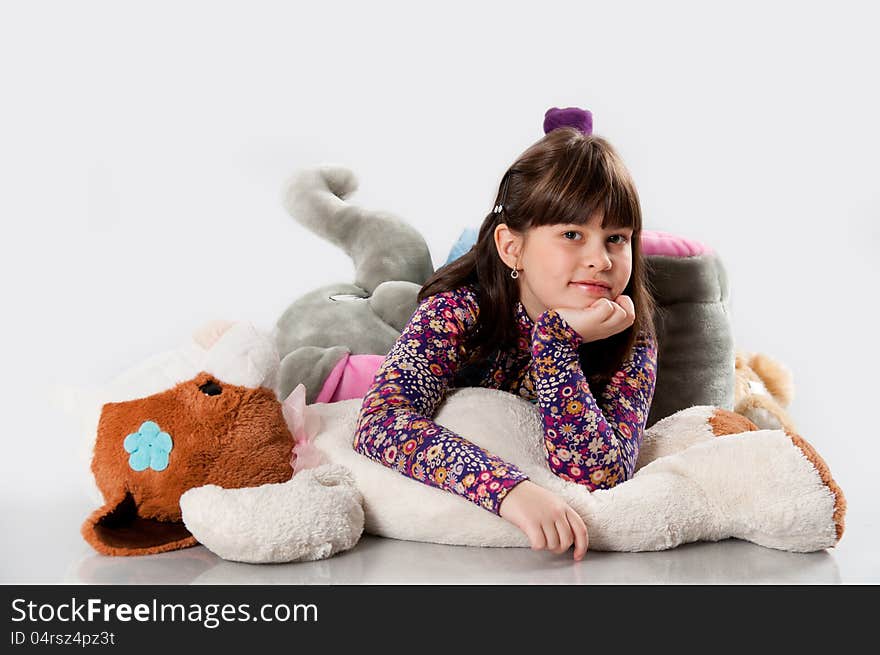 Cheerful girl playing with his toys on white background