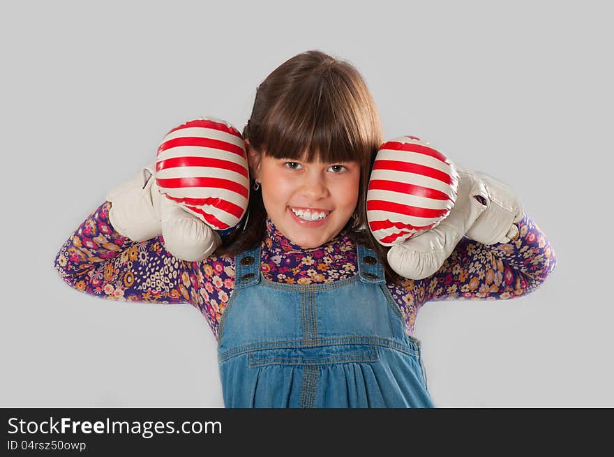 Cheerful girl with a boxing gloves in colorful dress