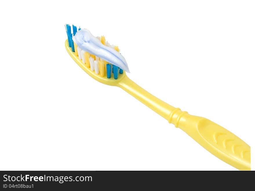 Yellow toothbrush coated with a toothpaste on a white background