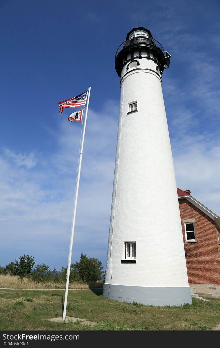 White lighthouse on the shore of Lake Superior with the American Flag. White lighthouse on the shore of Lake Superior with the American Flag