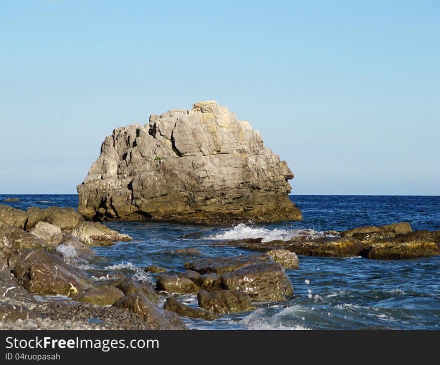 Huge fallen rock in the Black Sea. Martyan's cape in the reserve territory. Crimean peninsula, Ukraine. Huge fallen rock in the Black Sea. Martyan's cape in the reserve territory. Crimean peninsula, Ukraine.