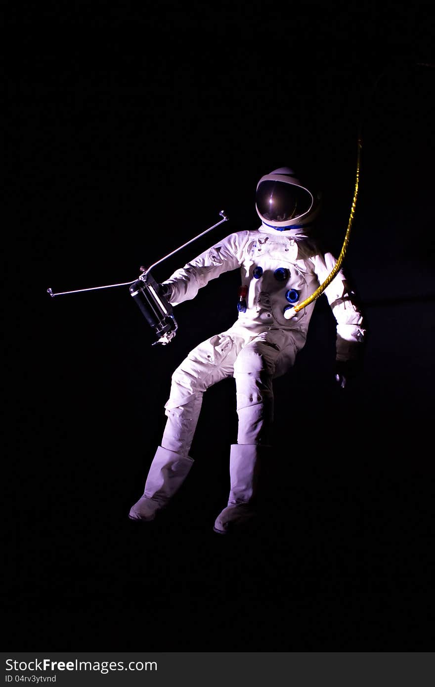 Astronaut wearing a pressure suit against a black background