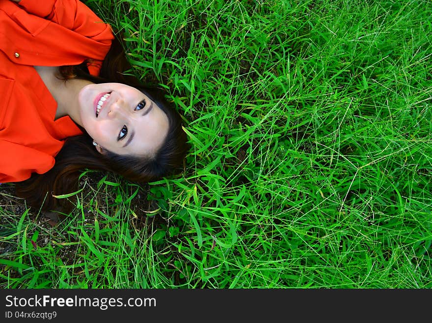 Smiling woman relaxes on the grass with copyspace. Smiling woman relaxes on the grass with copyspace