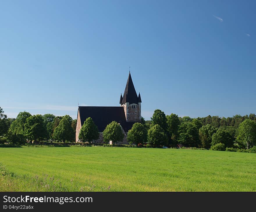 A church building in the field on a sunny day