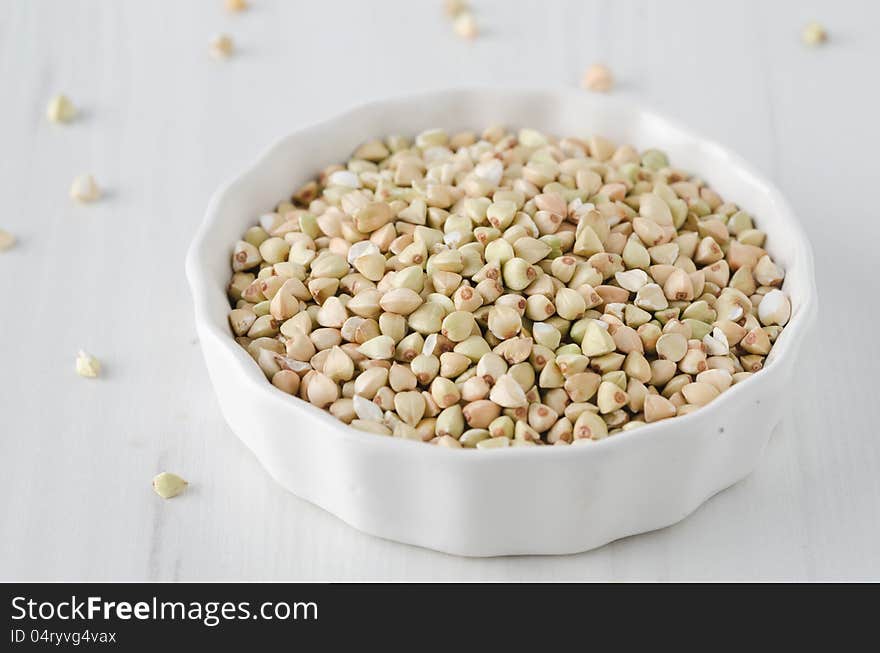 Green buckwheat in a white bowl on a white background