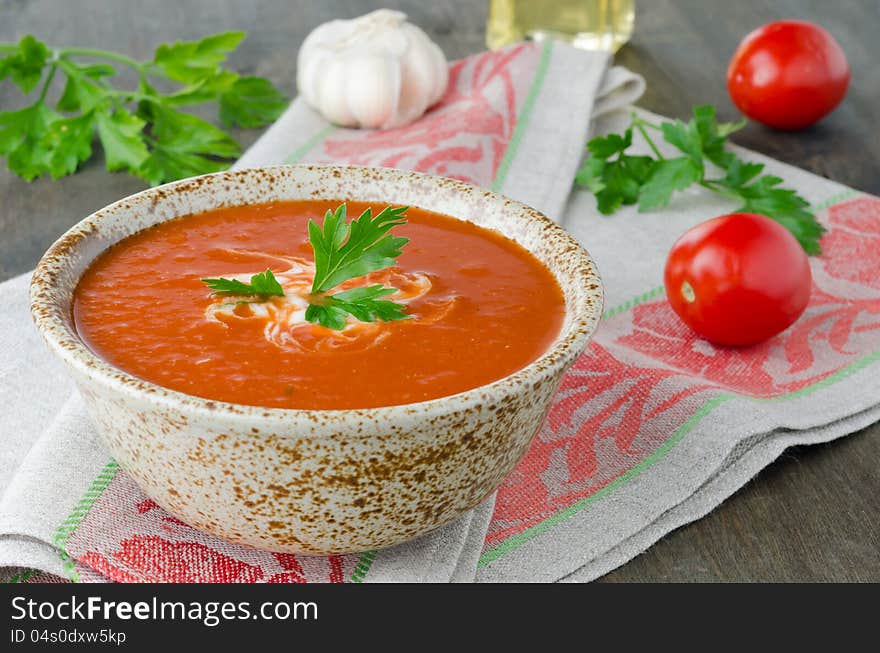 Hot tomato soup in ceramic bowl on the table, on a napkin, horizontal