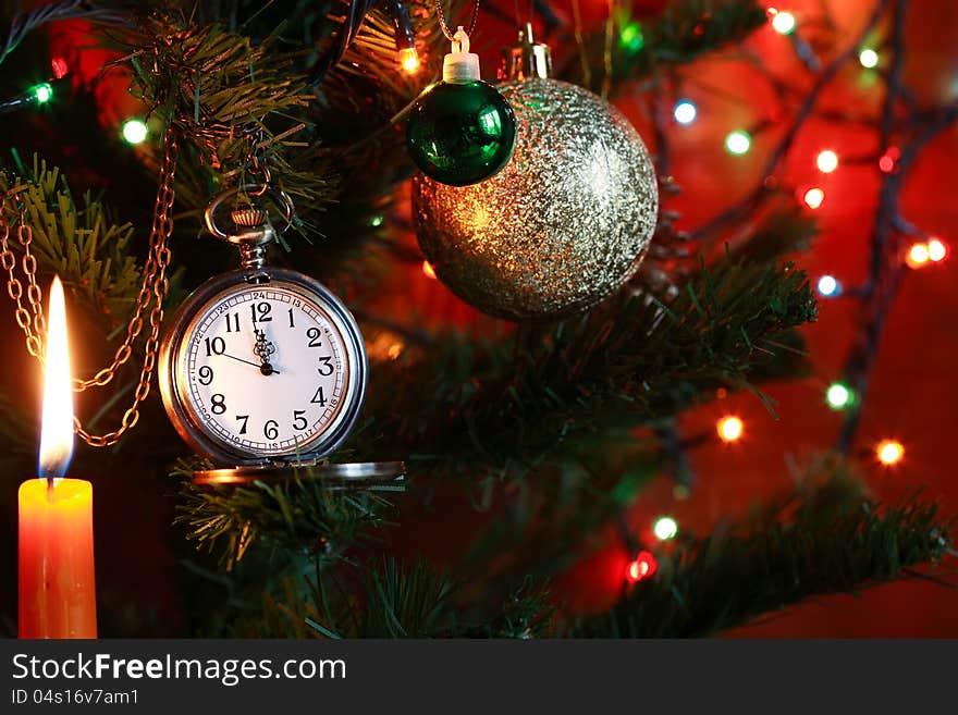 Vintage pocket watch hanging on Christmas tree near lighting candle. Vintage pocket watch hanging on Christmas tree near lighting candle