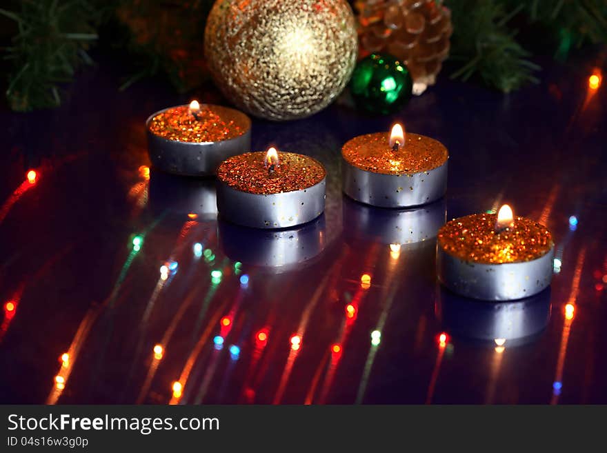 Few lighting candles on glass surfase with reflection on background with Christmas toys. Few lighting candles on glass surfase with reflection on background with Christmas toys