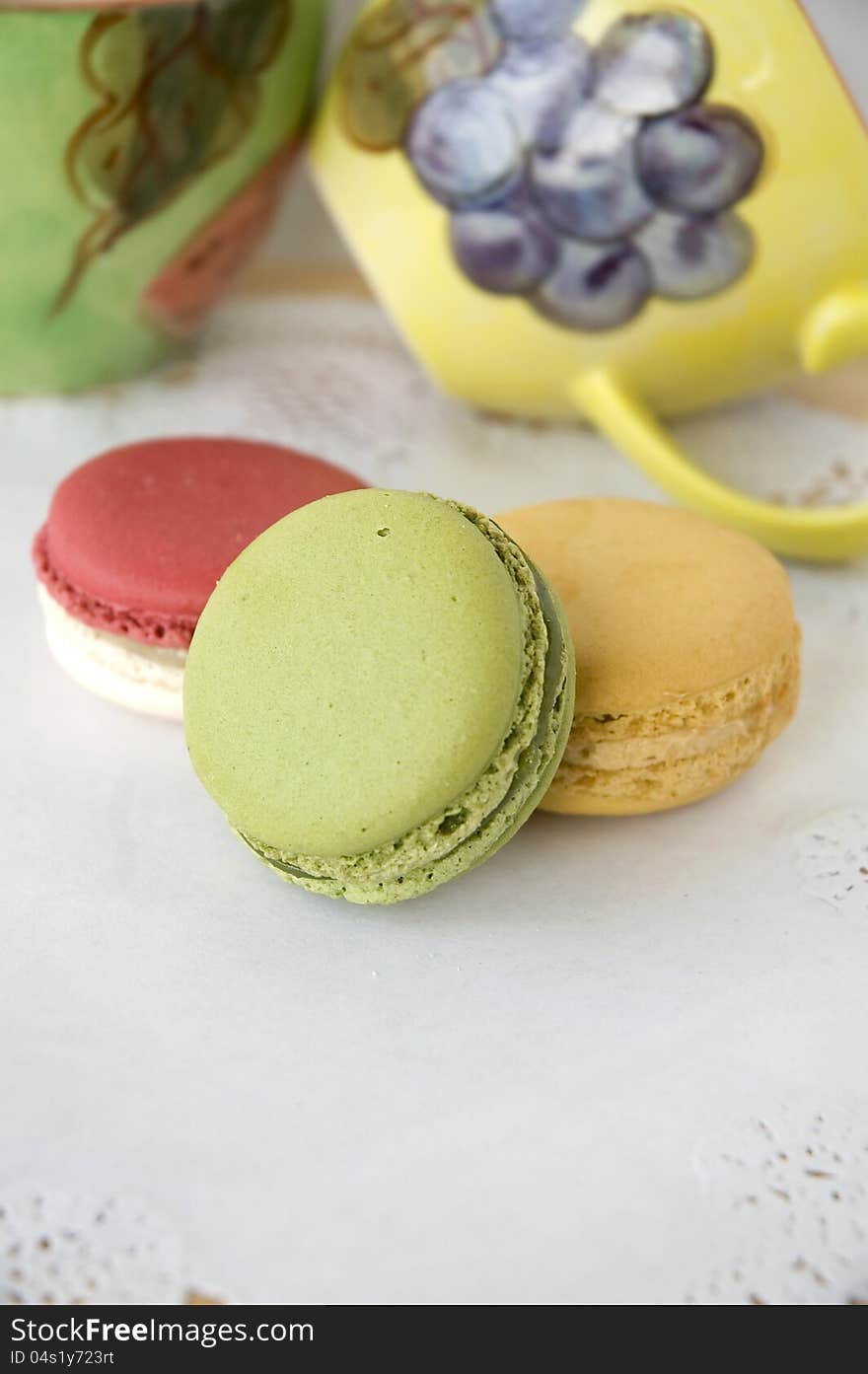 French macarons with colorful cups background