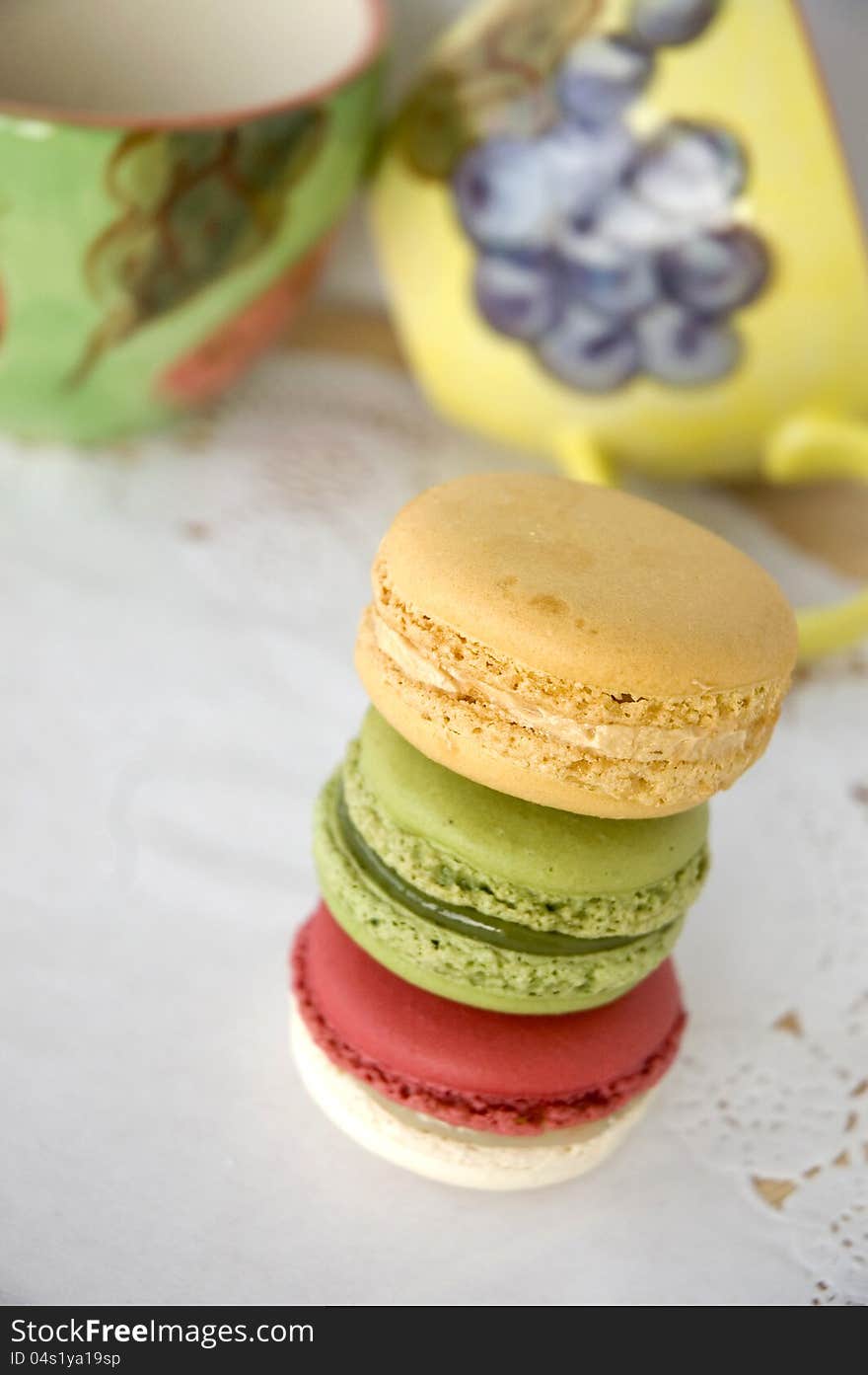 Stack of colorful macarons with colorful cups background