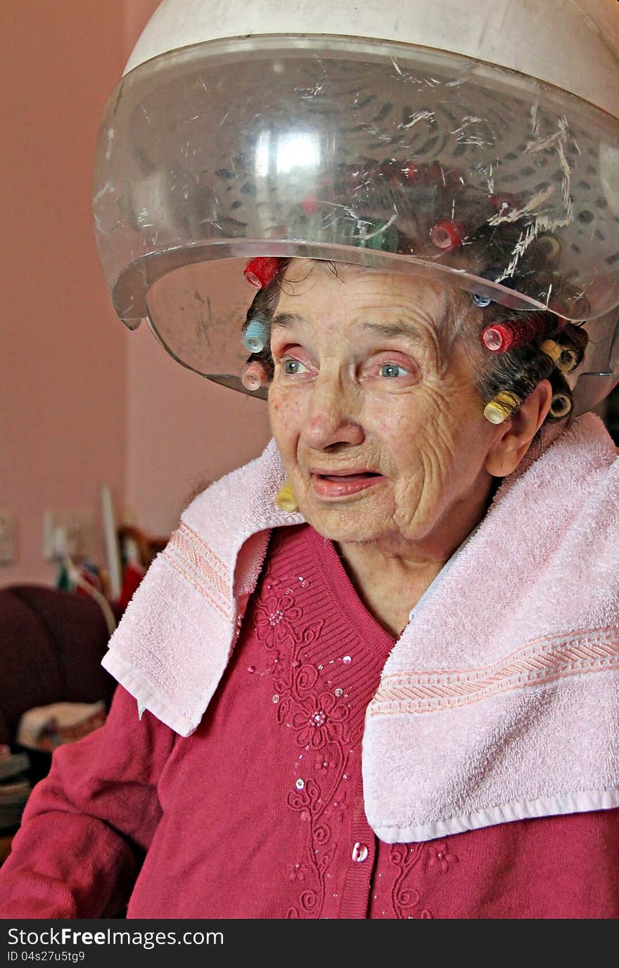 Photo of a female pensioner having her hair styled at home by a mobile hairdresser. Photo of a female pensioner having her hair styled at home by a mobile hairdresser.