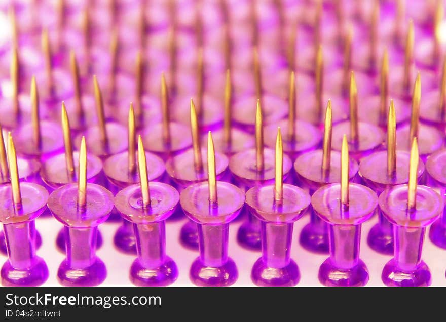 Purple pins close-up on white background standing points up. Purple pins close-up on white background standing points up