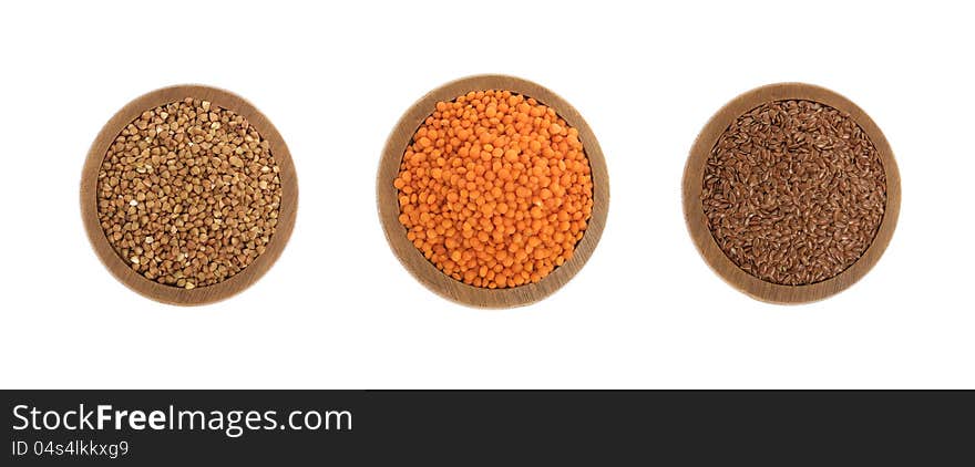 Buckwheat, red lentils and flax seeds on wooden plate isolated on white background. Buckwheat, red lentils and flax seeds on wooden plate isolated on white background