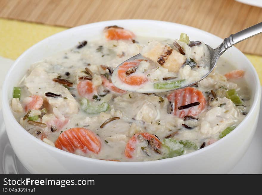 Bowl of chicken and rice soup with soup on a spoon. Bowl of chicken and rice soup with soup on a spoon