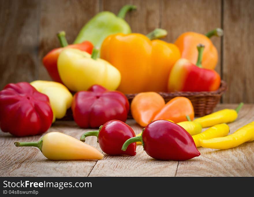 Colorful peppers on the wooden background