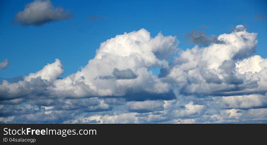 The pretty fluffy white cumulus clouds with some cumulonimbus drift across the blue Australian skies in spring with an occasional outpouring of precipitation which refreshes the new lush green growth of plants and grasses. The pretty fluffy white cumulus clouds with some cumulonimbus drift across the blue Australian skies in spring with an occasional outpouring of precipitation which refreshes the new lush green growth of plants and grasses.