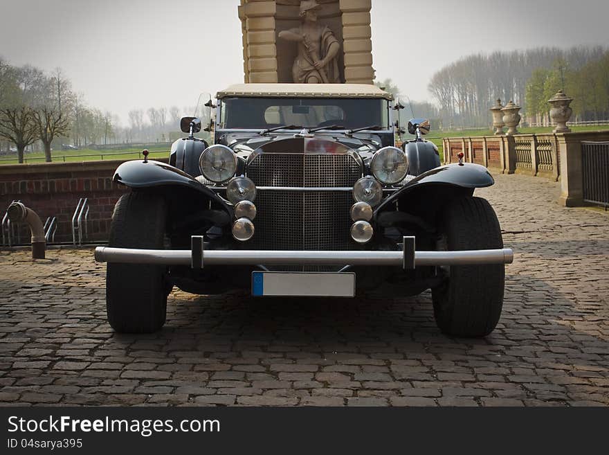 Classic looking limousine Excalibur in castle courtyard. Classic looking limousine Excalibur in castle courtyard