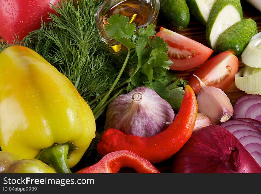 Yellow Bell Pepper and Various Vegetables with Greens, Garlic, Red Onion, Cucucmber and Tomatoes close up