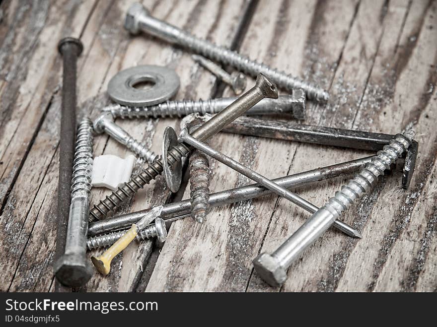 Metal nails and  screws  on wooden background