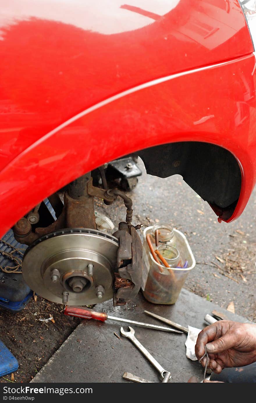 Mechanic checking spring to clip caliper together. Mechanic checking spring to clip caliper together.