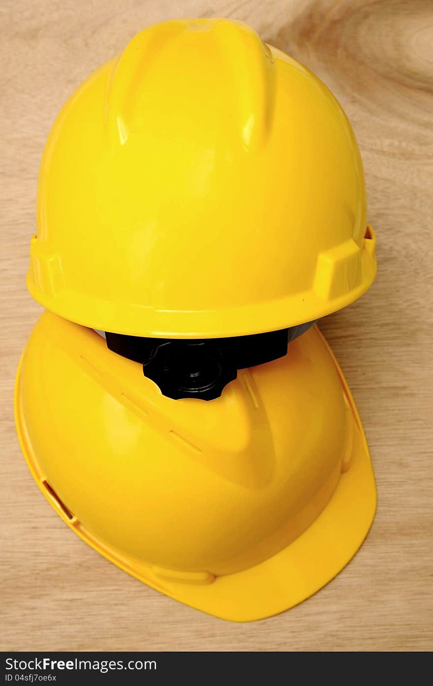 Two yellow helmet with wooden background