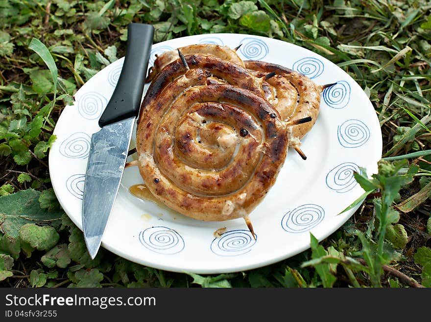 Sausages on a plate with a knife. Sausages on a plate with a knife