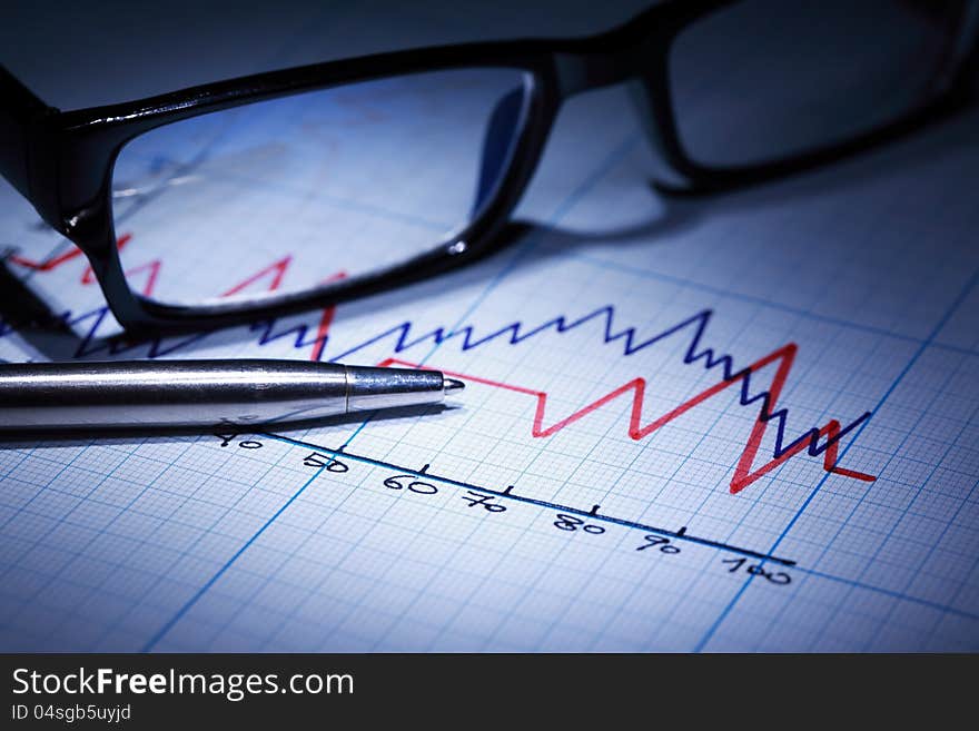 Business concept. Closeup of spectacles and pen on graph paper with diagram. Business concept. Closeup of spectacles and pen on graph paper with diagram