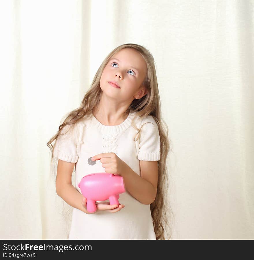 Little Blond Girl Puts Coin Into Piggy Moneybox