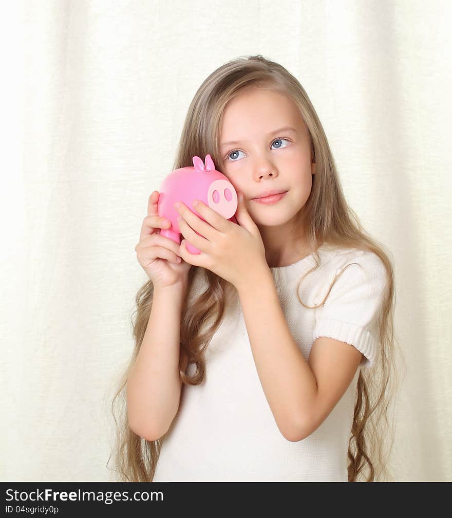 Little blong girl hearing how much money in piggy moneybox and dreaming about future purchase. Little blong girl hearing how much money in piggy moneybox and dreaming about future purchase