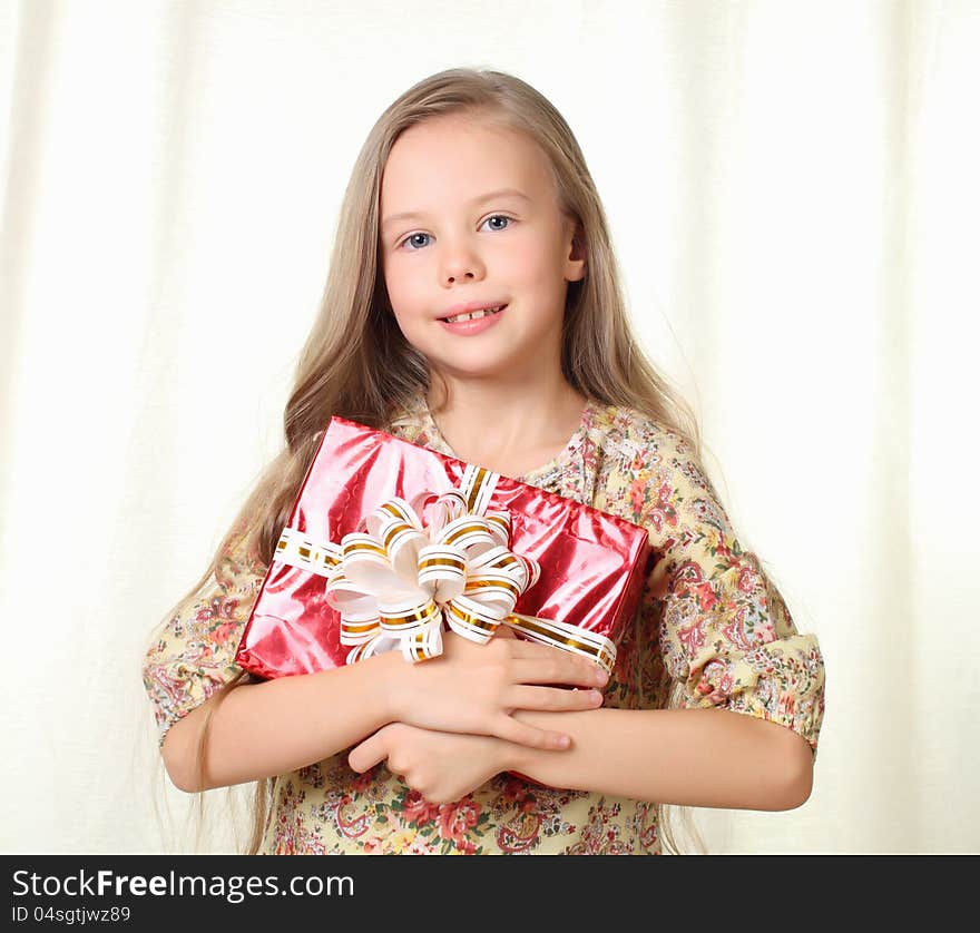 Little Blond Girl Holding A Red Glamorous Gift