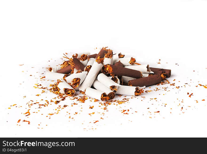 Pile of brown and white broken cigarettes on a white background. Pile of brown and white broken cigarettes on a white background