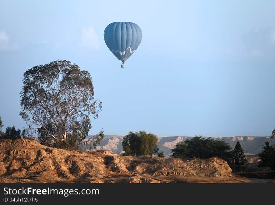 Balloon flying against a rocky landscape