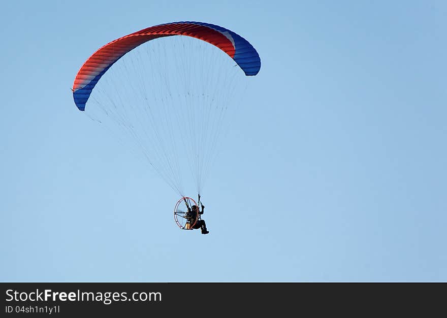 Paratrooper flying in the blue sky