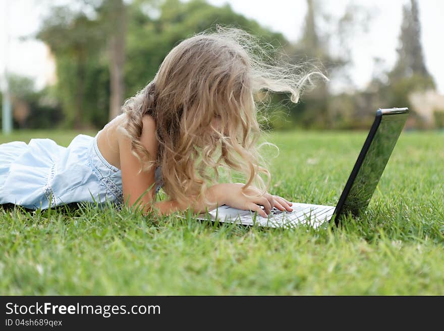 Blond  girl with laptop outdoors