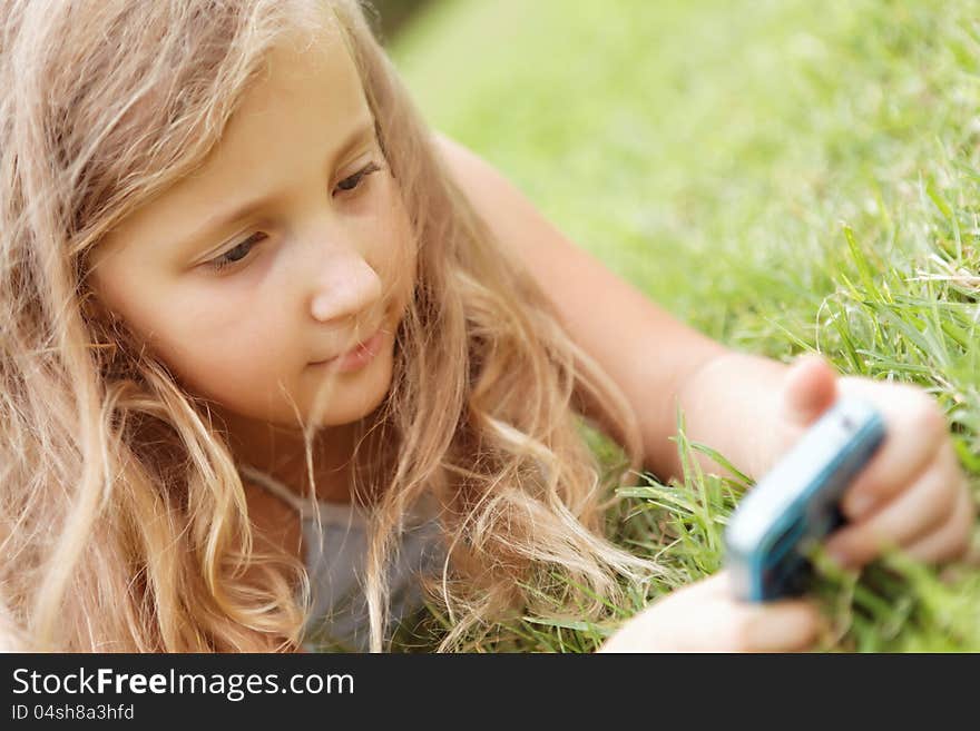 Pretty baby girl outdoors with a mobile phone