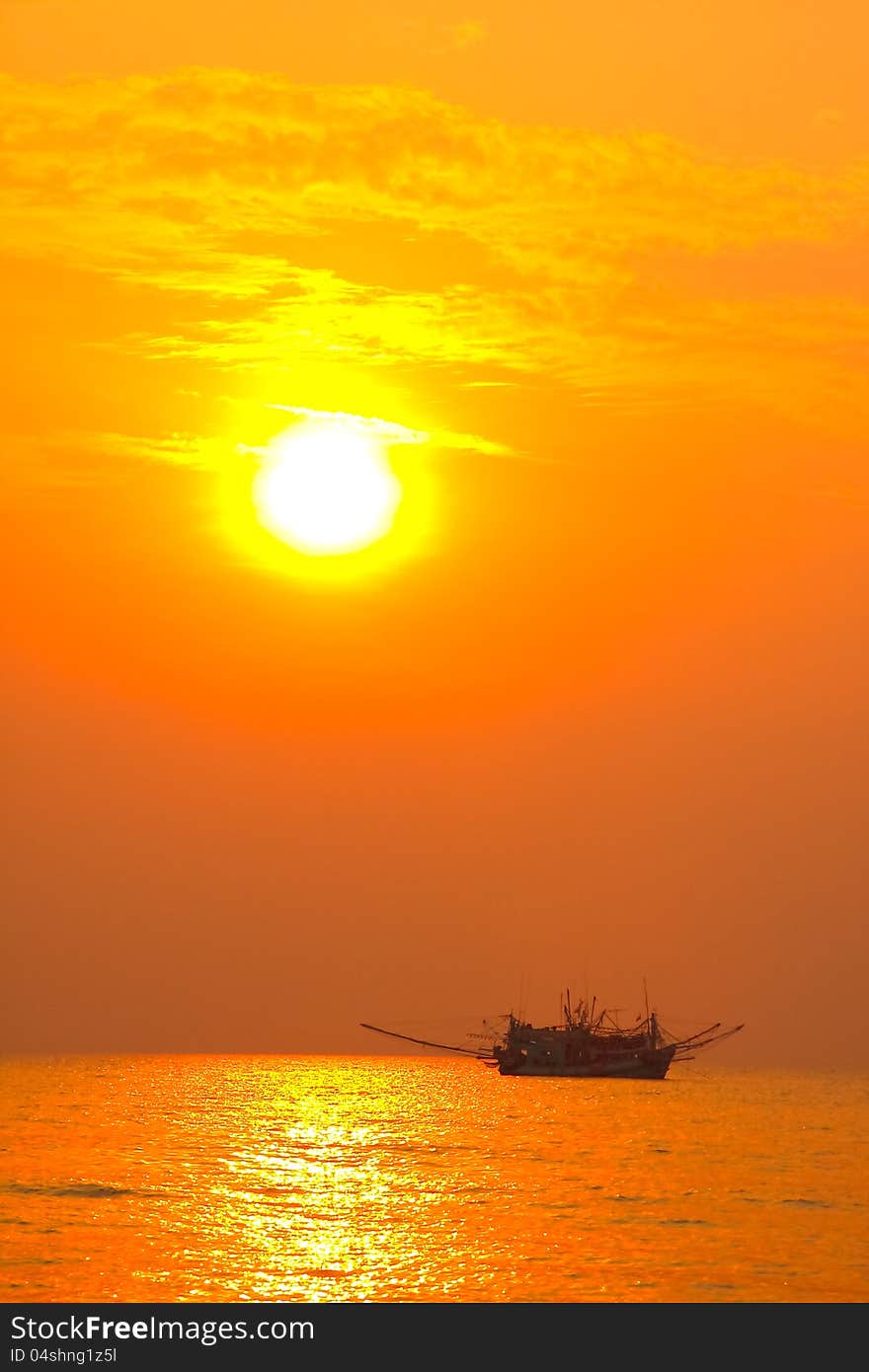 Fishing boat in sunset silhouette