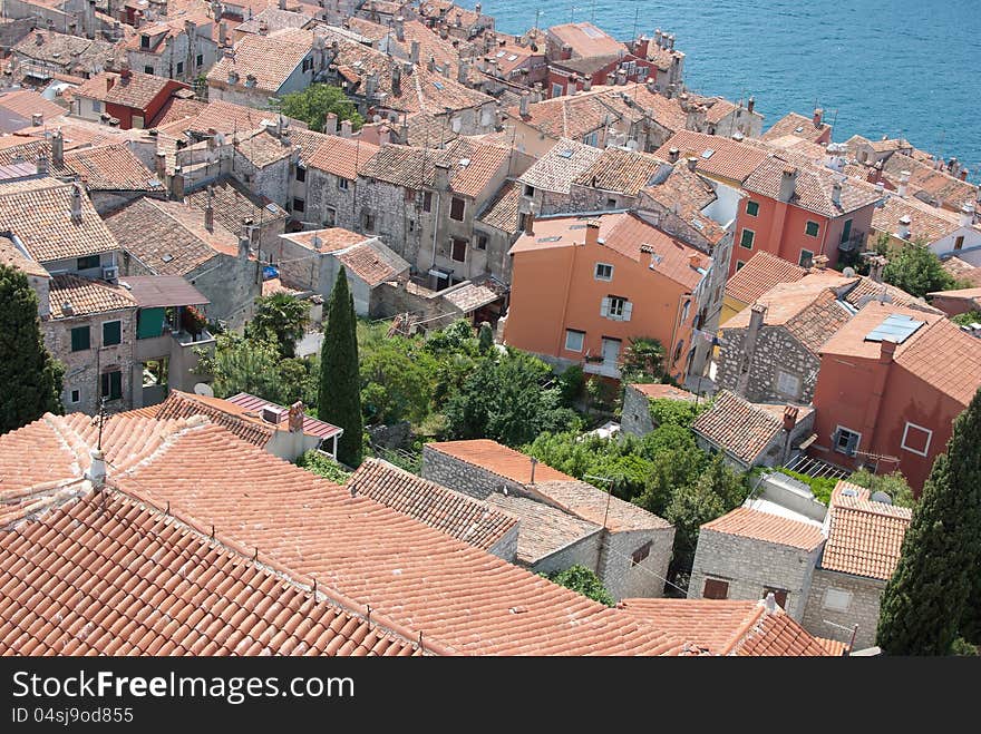 Old mediaeval village streets and red Mediterranean roof in Croatia (Rovinj) with sea and cypress trees in background, seen form bell church of saint Evfemija. Old mediaeval village streets and red Mediterranean roof in Croatia (Rovinj) with sea and cypress trees in background, seen form bell church of saint Evfemija