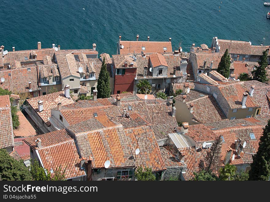 Old mediaeval village streets and red Mediterranean roof in Croatia (Rovinj) with sea and cypress trees in background, seen form bell church of saint Evfemija. Old mediaeval village streets and red Mediterranean roof in Croatia (Rovinj) with sea and cypress trees in background, seen form bell church of saint Evfemija