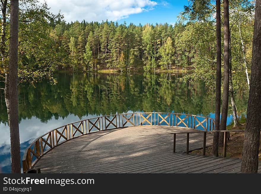 Forest Lake with reflection in the water and the observation deck