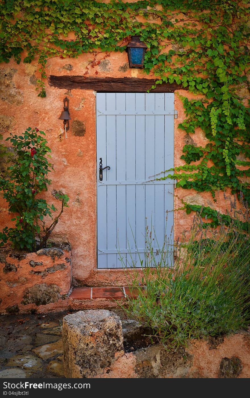 Old blue entrance door in orange wall, Provence, France. Old blue entrance door in orange wall, Provence, France