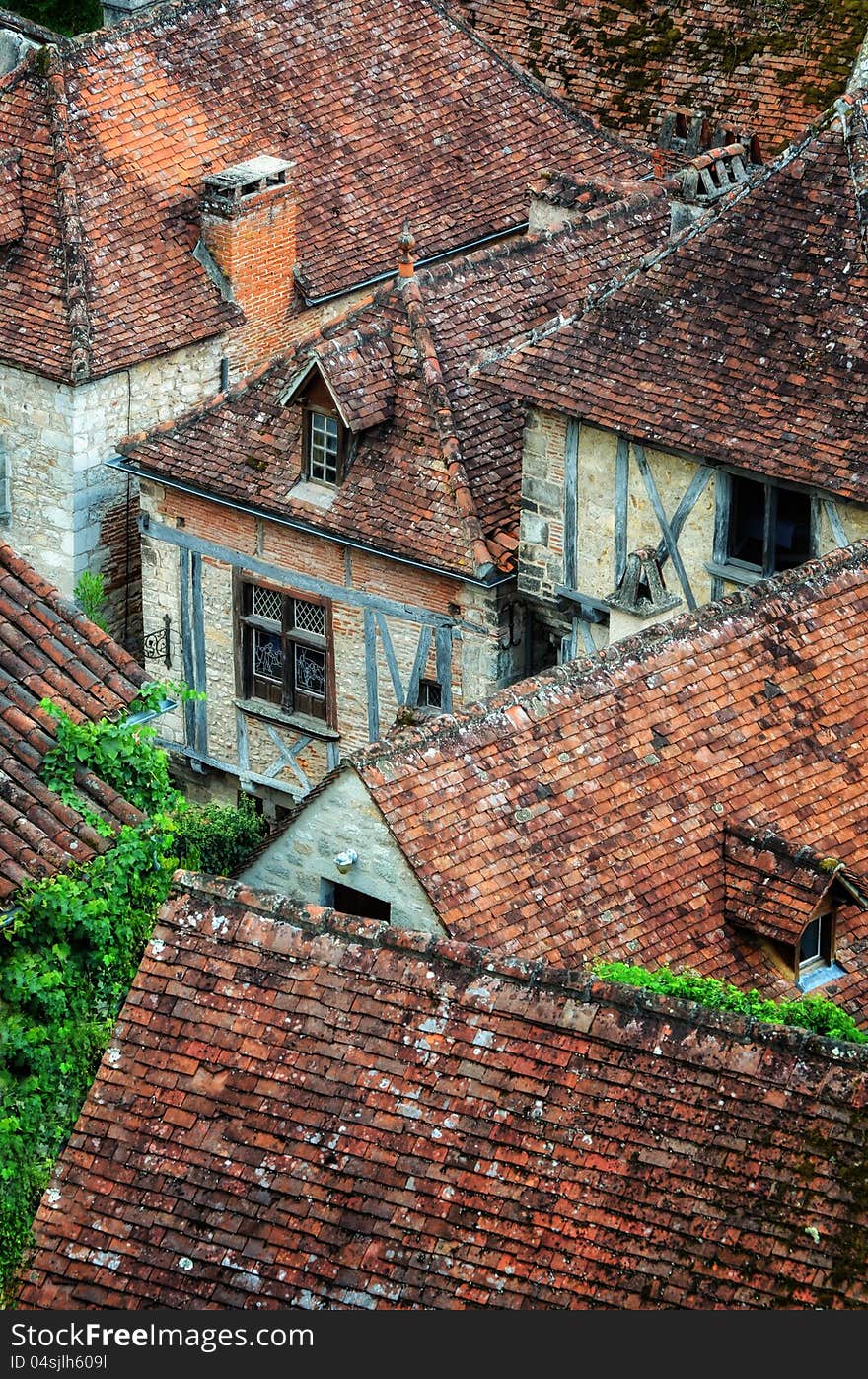 Old village detail of houses with brick roofs and windows, France