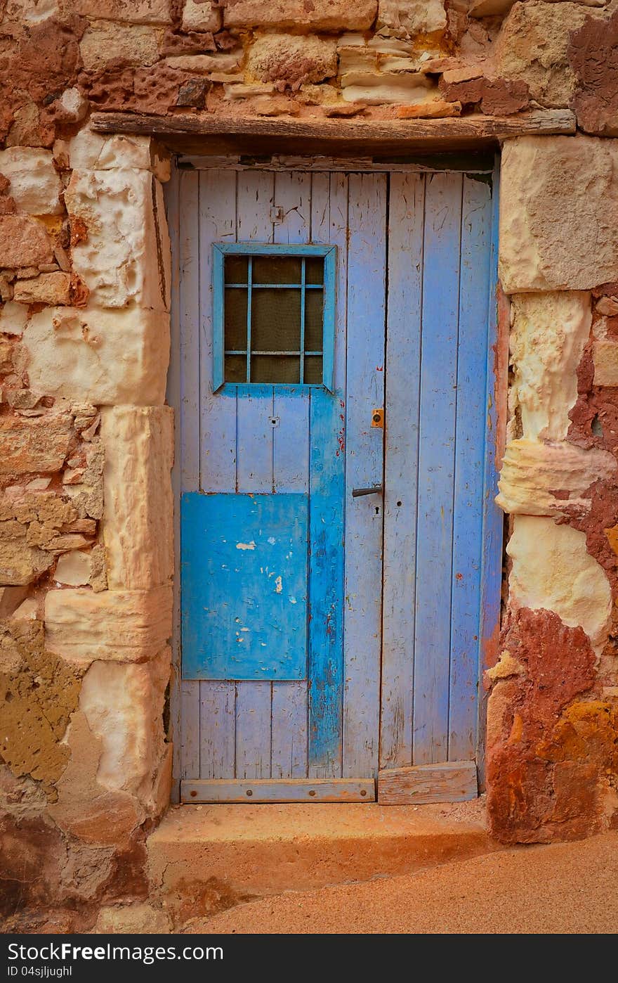 Old textured door in a stone wall, Provence