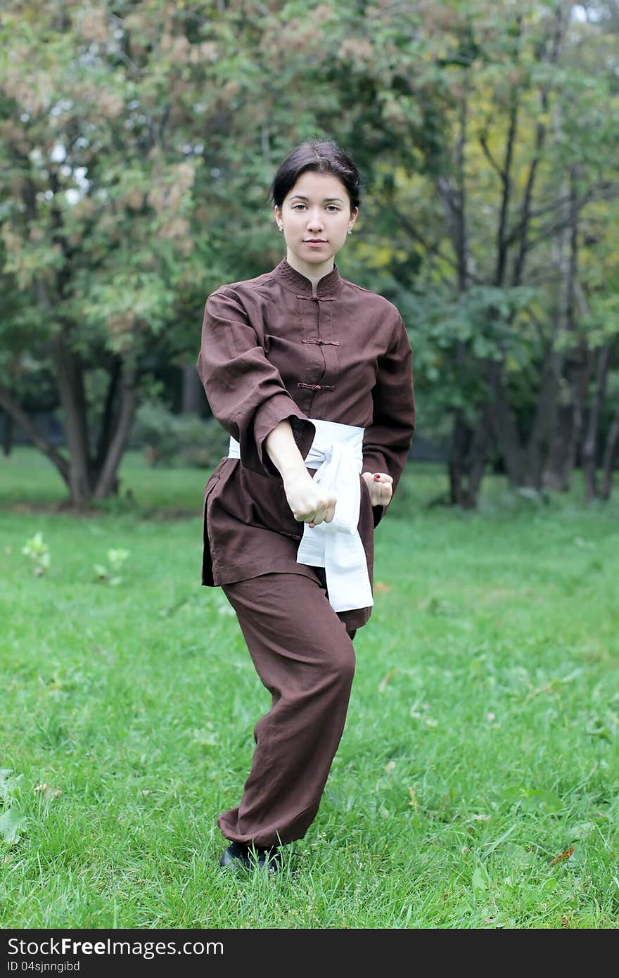 Zen pretty woman practicing exercise kung fu, chi kung or tai chi in natural park. Zen pretty woman practicing exercise kung fu, chi kung or tai chi in natural park