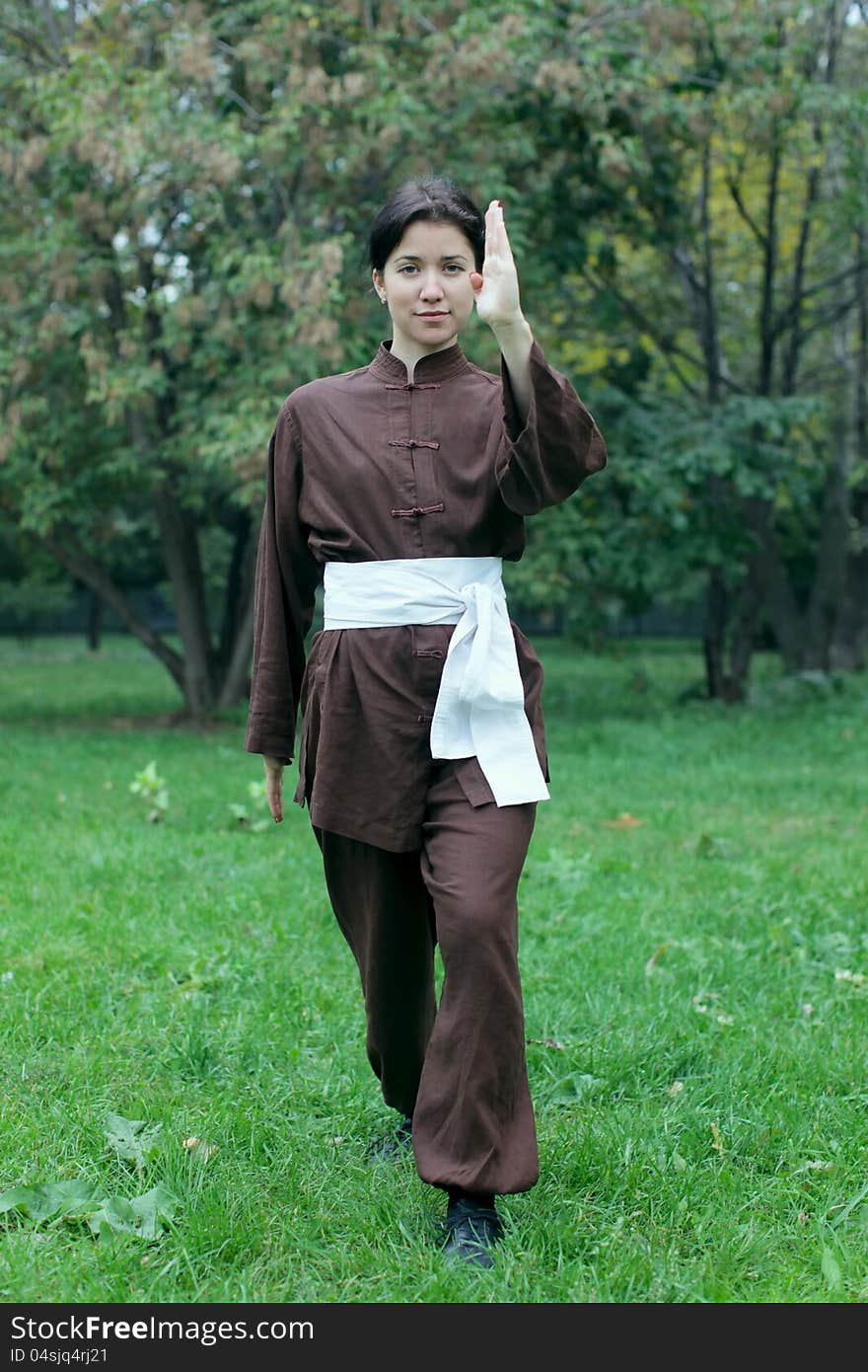 Zen pretty woman practicing exercise kung fu, chi kung or tai chi in natural park. Zen pretty woman practicing exercise kung fu, chi kung or tai chi in natural park