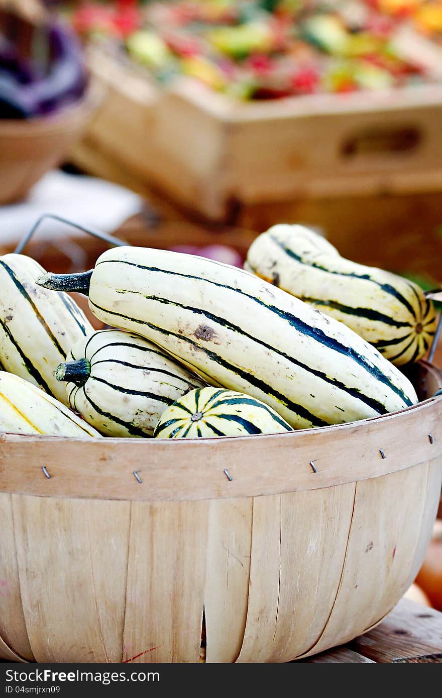 Striped delicata squash in a basket.