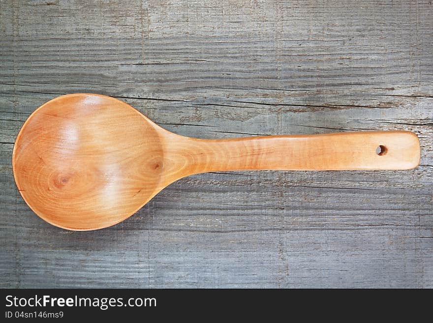 Old wooden spoon on textured board.